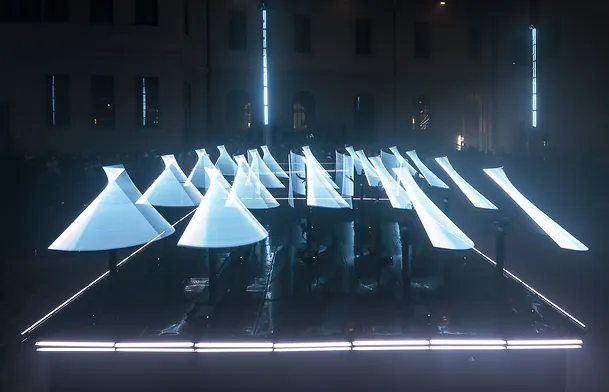 Dorna robots in CODA - a stage performance by Collectif Scale - showcasing their high-degree design and motion profiles - creating aesthetic visuals with lights.